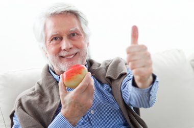old man holding a fruit