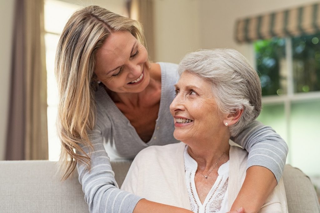 mature woman hugging elderly mother