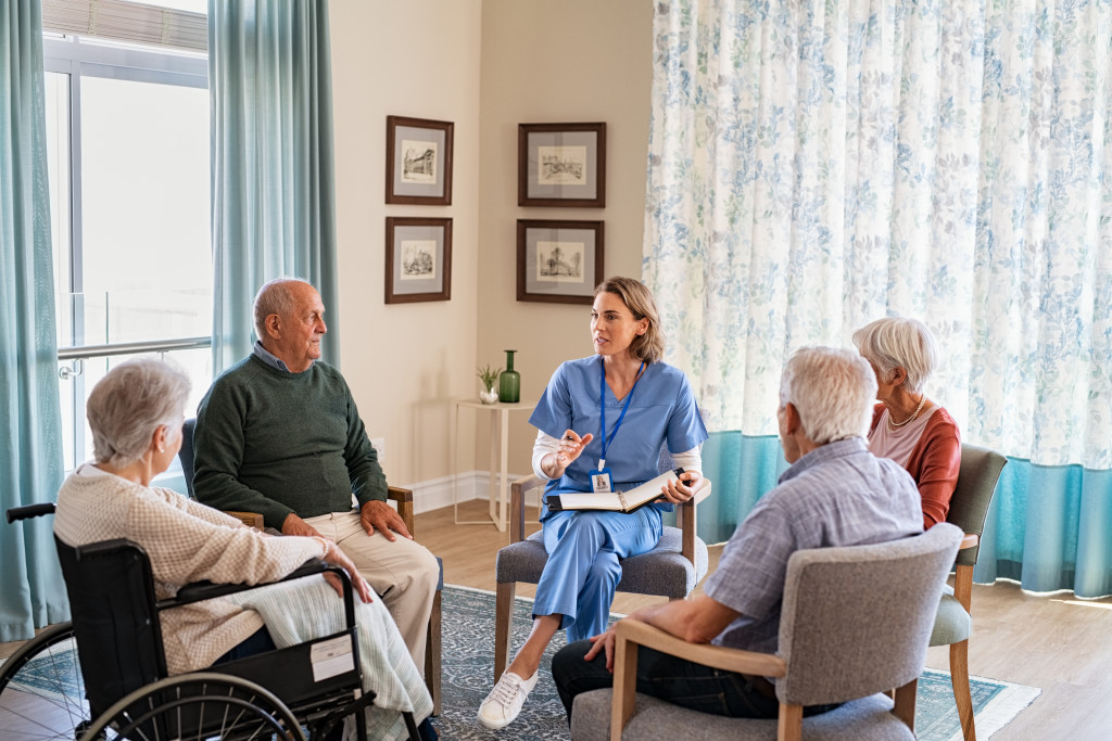 a group of senior people listening to a young nurse